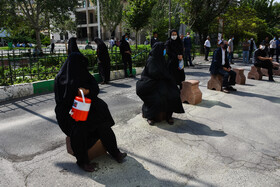 سایه عابران نشسته که بر روی زمین افتاده است.