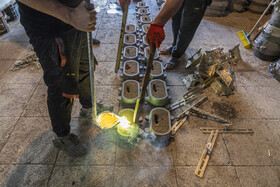 کارگران در حال ریختن مذاب در قالب هستند.