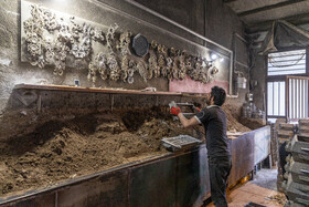 کارگری در حال باز کردن قالب‌ها و درآوردن شکل تسمه برای درست کردن  وسایل کاربردی هست.